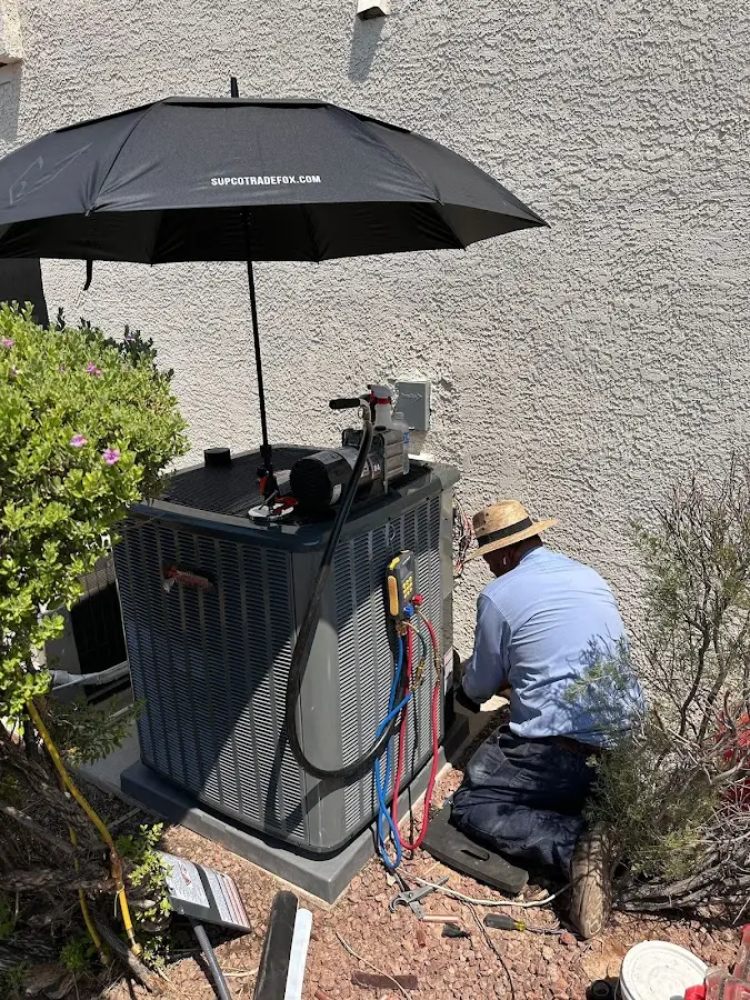 HVAC technician performing outdoor AC maintenance in Vergennes